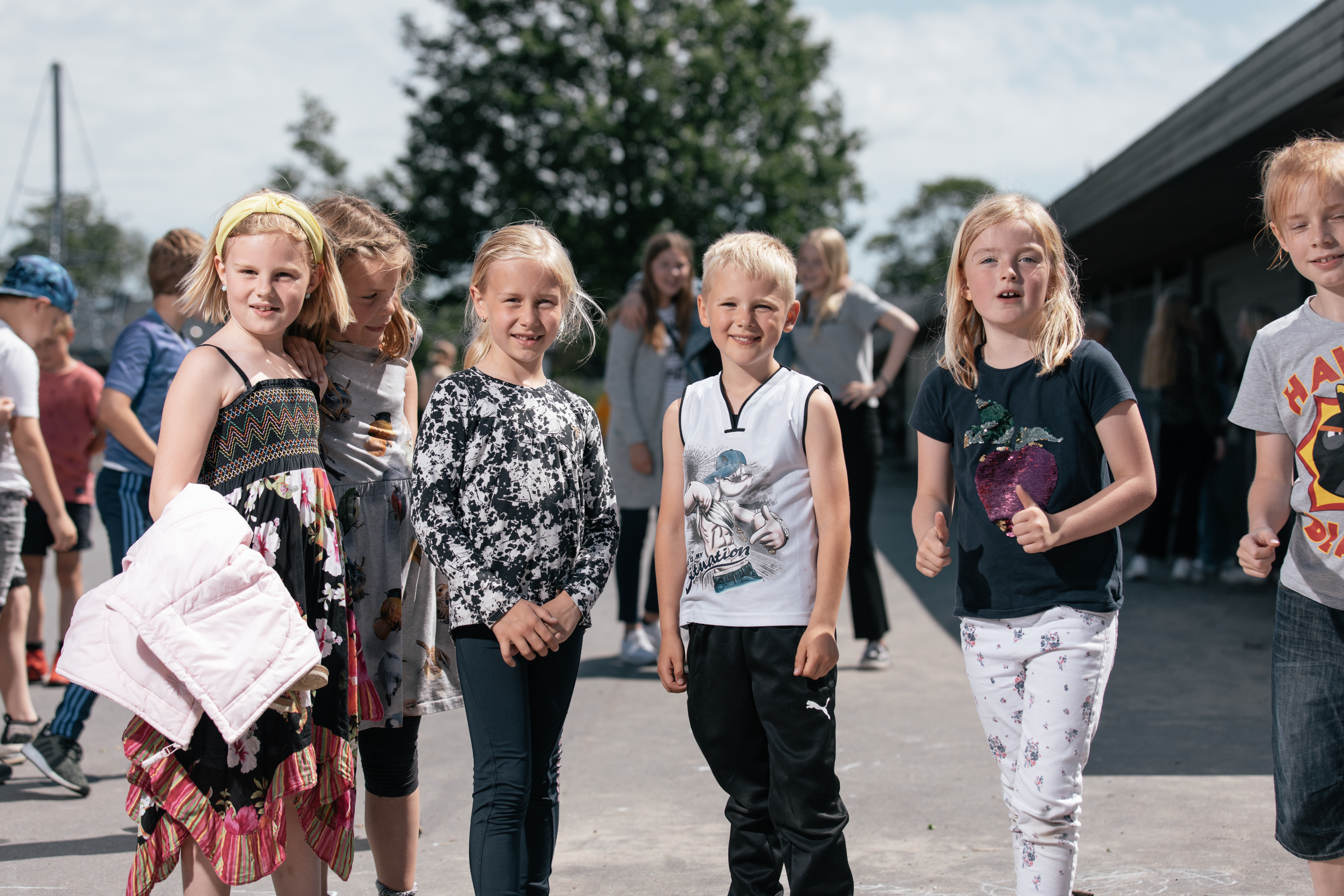 Billede af elever i skolegården stående ved siden af hinanden